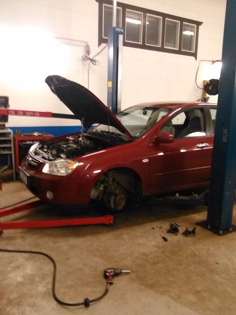 Henkilöauto huollossa, konepelti auki