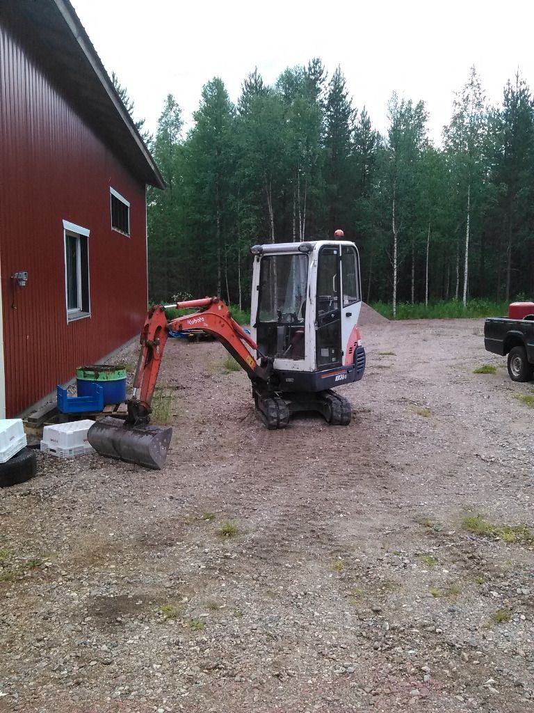 Kubota-minikaivinkone korjaamorakennuksen edustalla